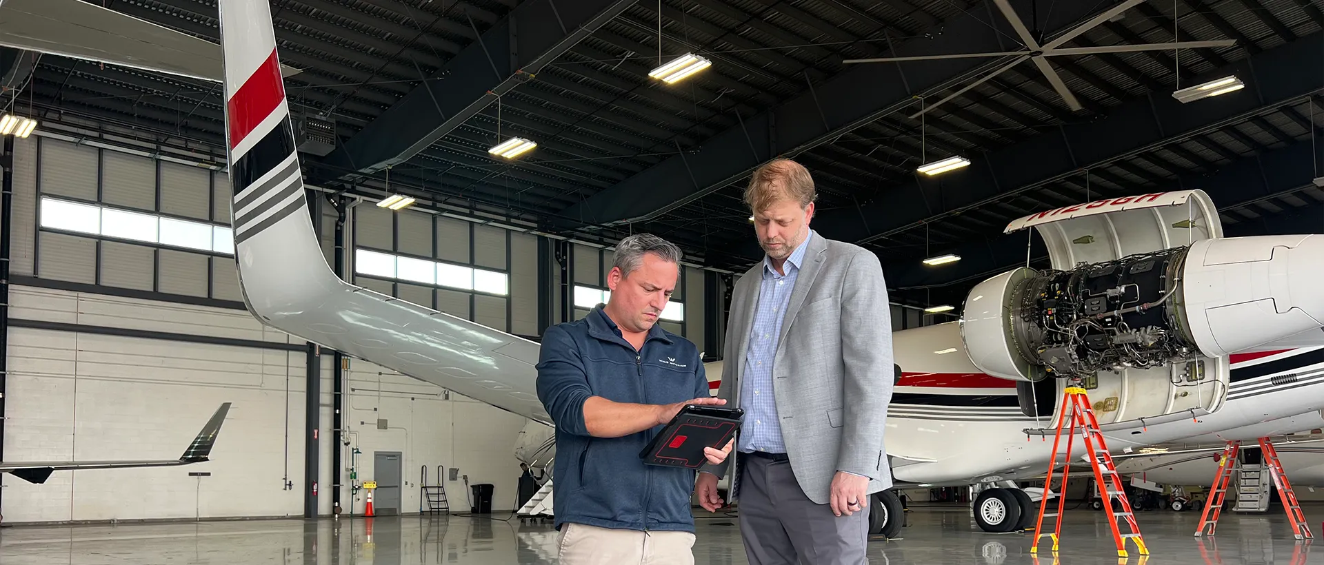 Wing Aviation CEO and technician speaking in the hangar.