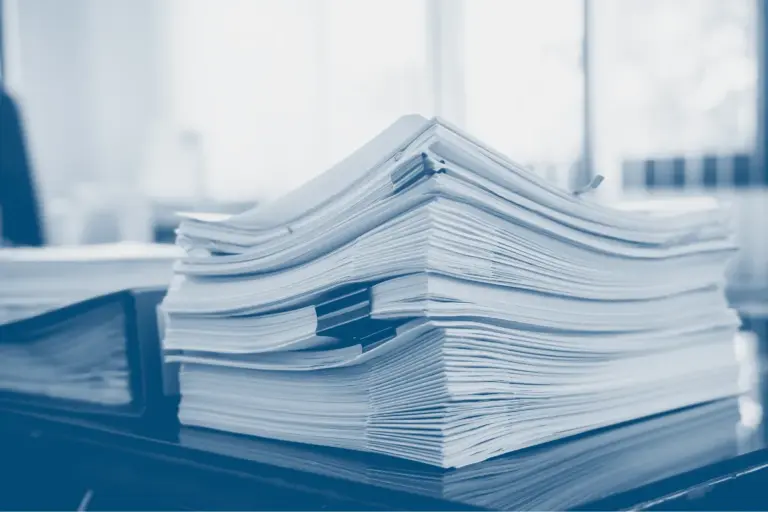 Overloaded safety paperwork illustrating SMS over-engineering